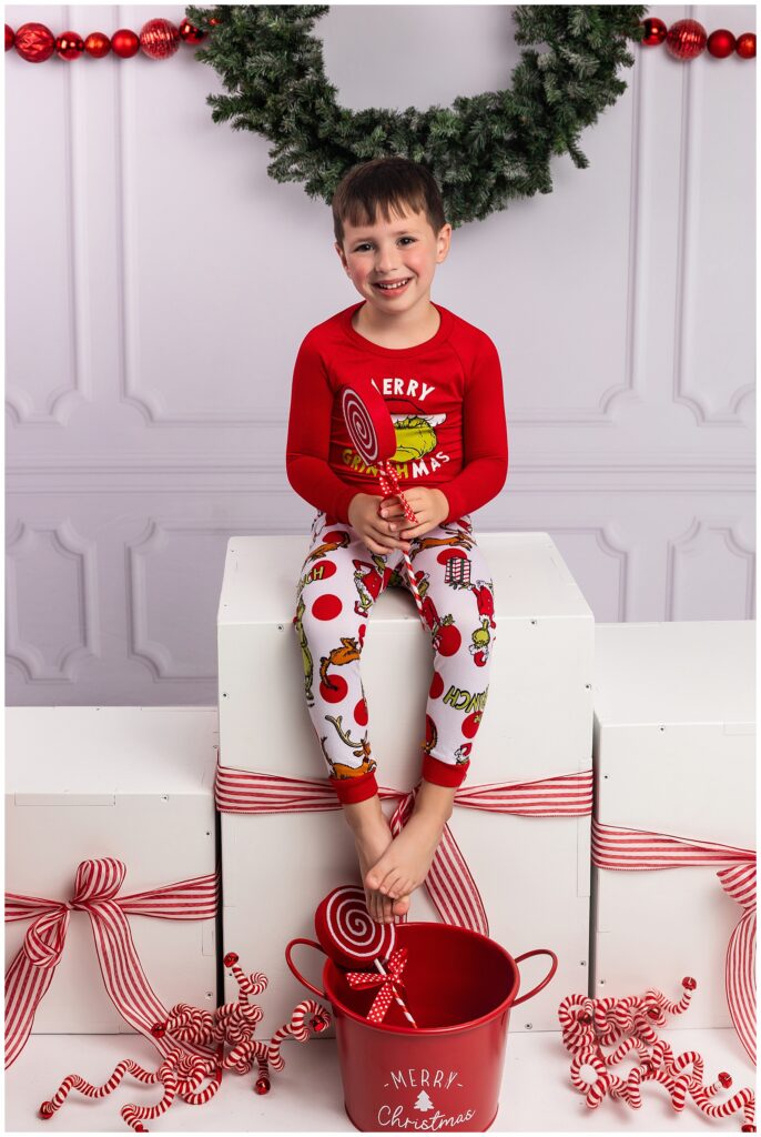 Kid sitting on presents in Christmas pictures